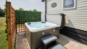 A hot tub with steps, a wooden fence, and a sign that reads "This is our happy place."