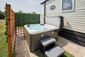 Un jacuzzi con escalones, una valla de madera y un letrero que dice 'Este es nuestro lugar feliz'.