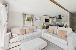 A compact living space with a sofa set, kitchenette, and a dining area.
