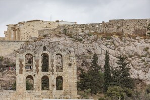 An ancient stone structure with multiple arches and a rugged hillside backdrop. - Massive 2-combo apt Unbeatable Acropolis Views 9pax (Athens)