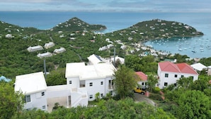A coastal village with white buildings, a marina with boats, and lush greenery. - Sunset Dream - 1BR Hillside Retreat – A/C & Ocean Views, Newly Updated. (St John)