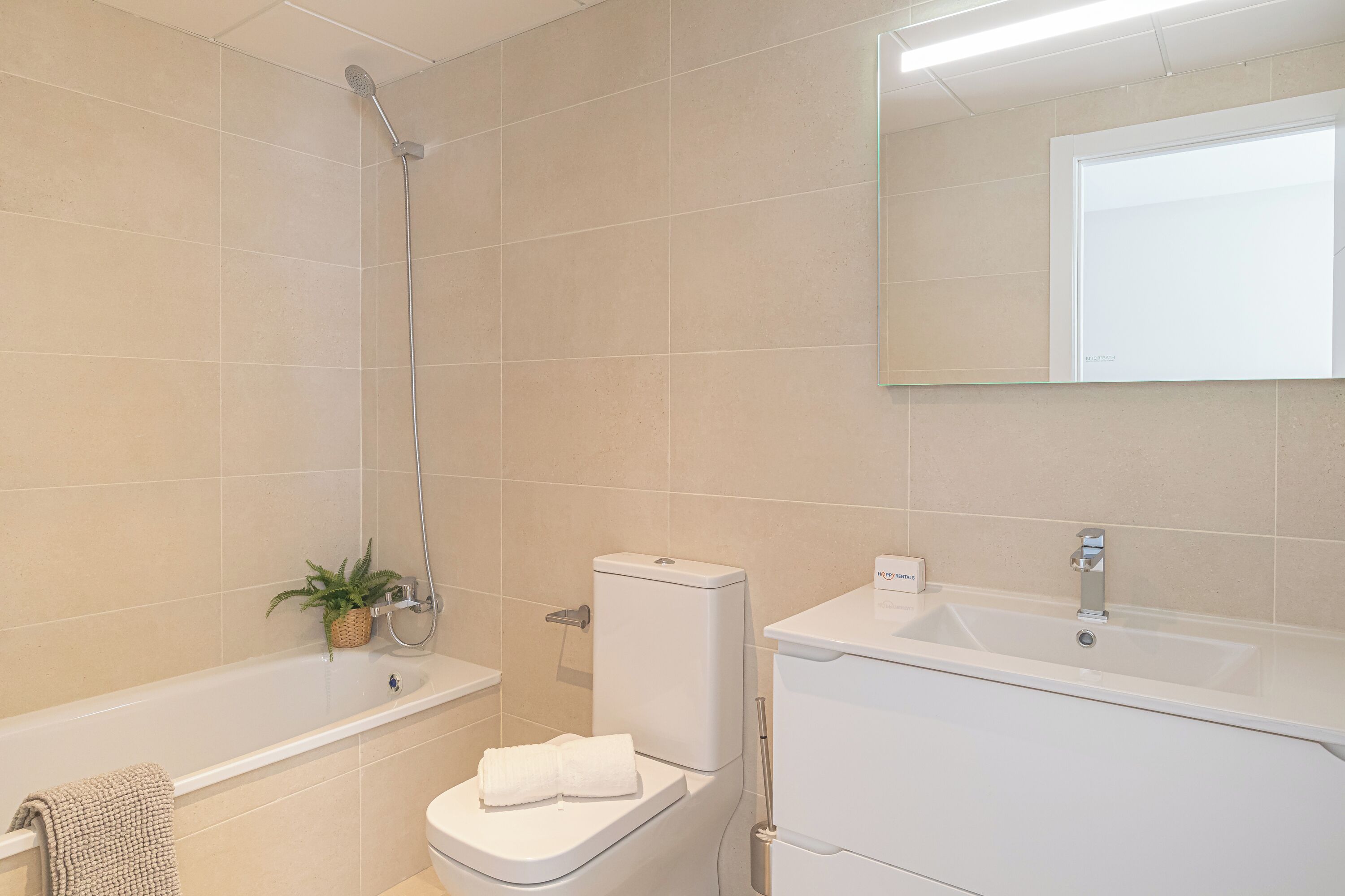 A modern bathroom with a bathtub, toilet, and sink.