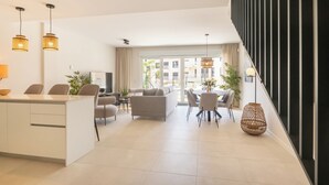 Un espacio de estar moderno con cocina, comedor y una escalera.