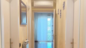 A hallway with wooden flooring, white doors, and an air conditioning unit. - 5 min from the sea large Apartment - Wifi and Air Conditioning (Lido di Camaiore)
