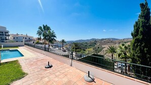 A rooftop terrace with a swimming pool, palm trees, and a view of distant hills. - Apartamento La Fuente At Home by At Home Costa del (Frigiliana)