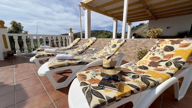 A terrace with white lounge chairs, some with towels, and a pergola overhead. - Villa Paco by At Home Costa del Sol (Torrox)