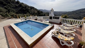 A pool with a view of mountains, white lounge chairs, and a white fence. - Villa Paco by At Home Costa del Sol (Torrox)