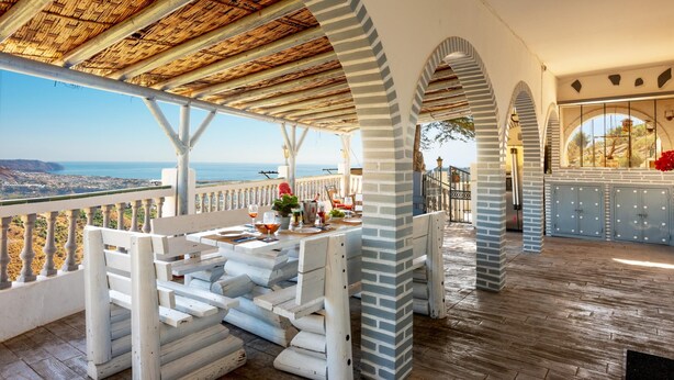 A terrace with a view of the sea, white wooden furniture, and a thatched roof. - Villa Las Palomas by At Home Costa del Sol (Torrox)