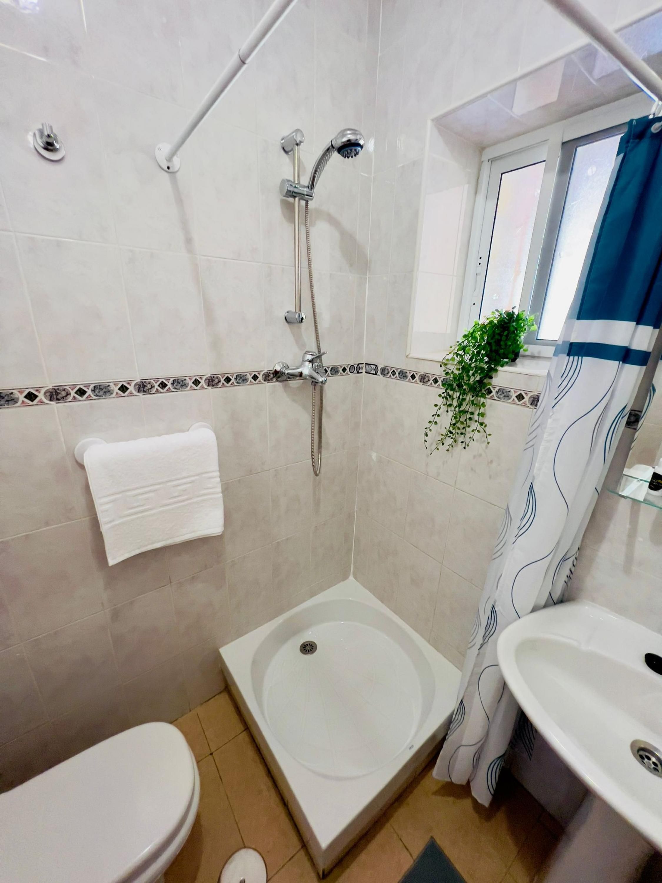 Ein Badezimmer mit Dusche, Toilette und Waschbecken.