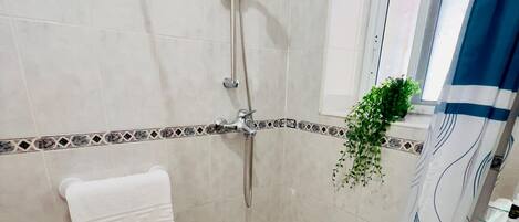 Ein Badezimmer mit Dusche, Toilette und Waschbecken.