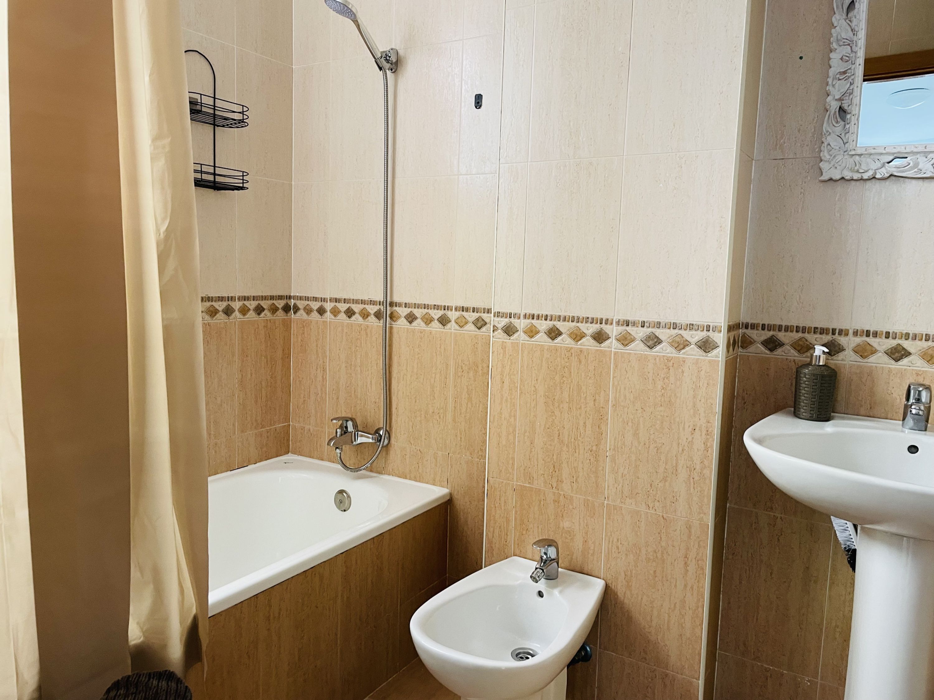 Une salle de bain avec une baignoire, un bidet et un lavabo.