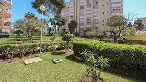 A well-maintained garden with manicured hedges, a variety of trees, and a green lawn.