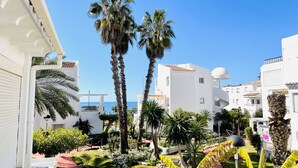 A residential area with white buildings, palm trees, and a clear blue sky. - Apartamento Laguna Beach by At Home Costa del Sol (Torrox)