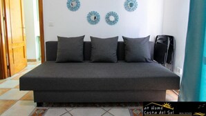 A bedroom with a bed, four pillows, and decorative wall art. - Apartamento Huelva Jimena by At Home Costa del Sol (Nerja)