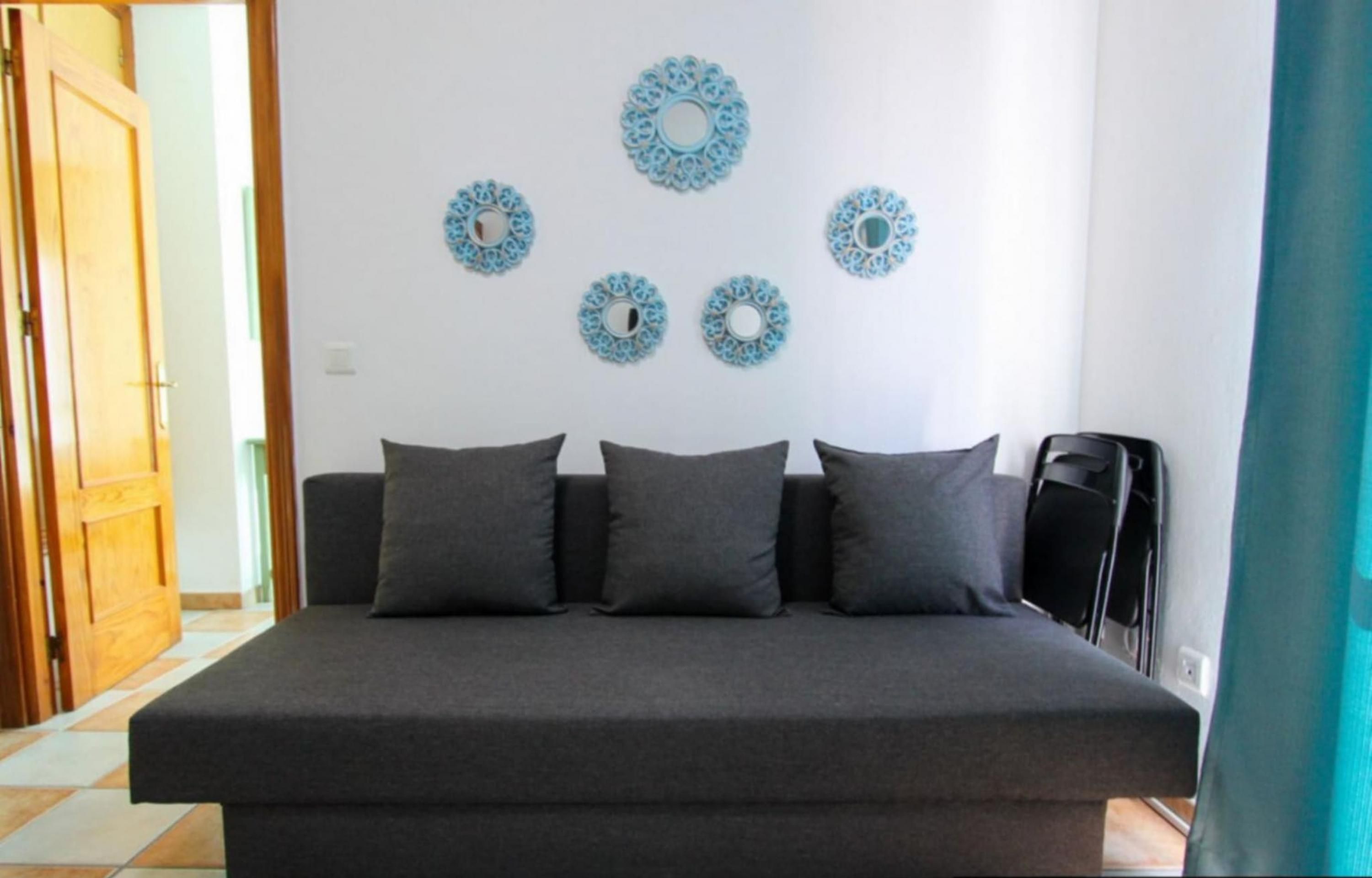 A bedroom with a bed, four pillows, and decorative wall art.
