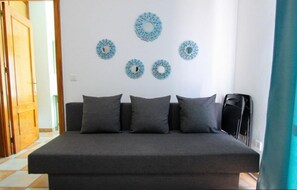 Un dormitorio con una cama, cuatro almohadas y decoración mural.