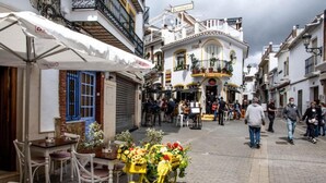 A narrow street with outdoor seating and a yellow bicycle with flowers.