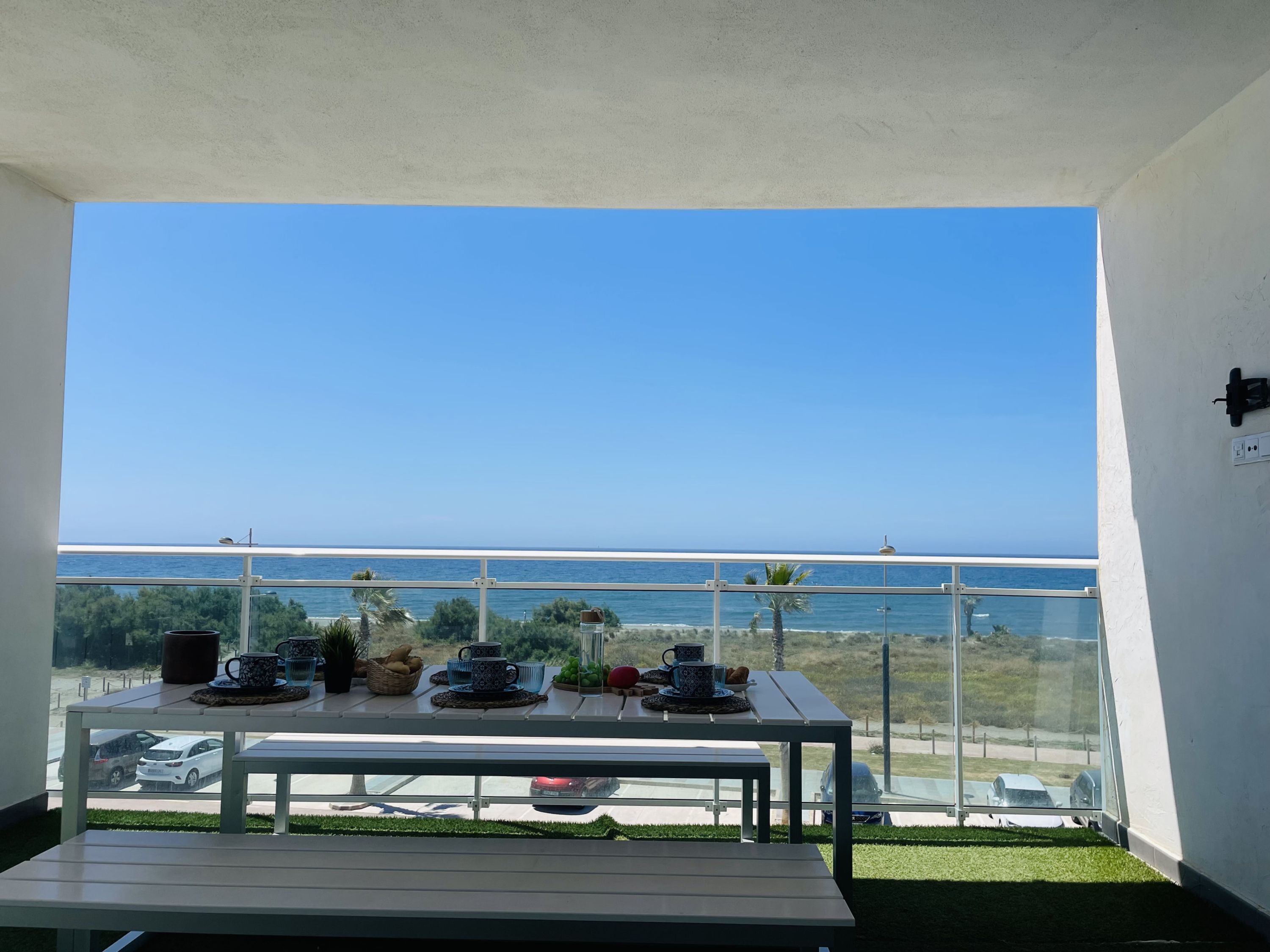 Un balcone con un tavolo apparecchiato per la colazione e vista sulla costa.