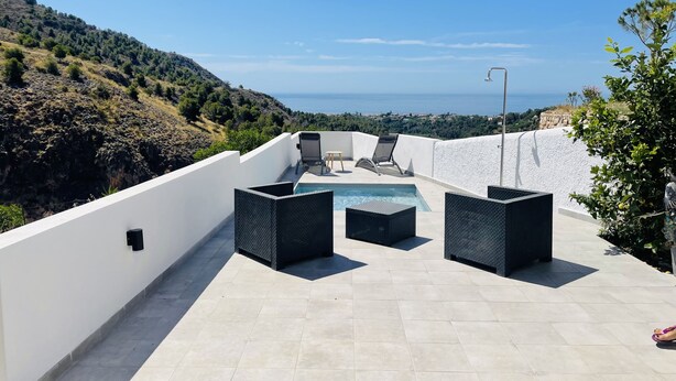 A rooftop terrace with a pool, lounge chairs, and a view of the sea. - Casa Paraiso en Frigiliana (Frigiliana)
