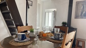 A dining table with chairs, a glass top, and a small side table with a plant. - Casa Paquita con Piscina Privada en Maro By At Hom (Nerja)