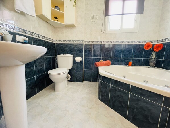 Ein Badezimmer mit Toilette, Waschbecken und Badewanne.