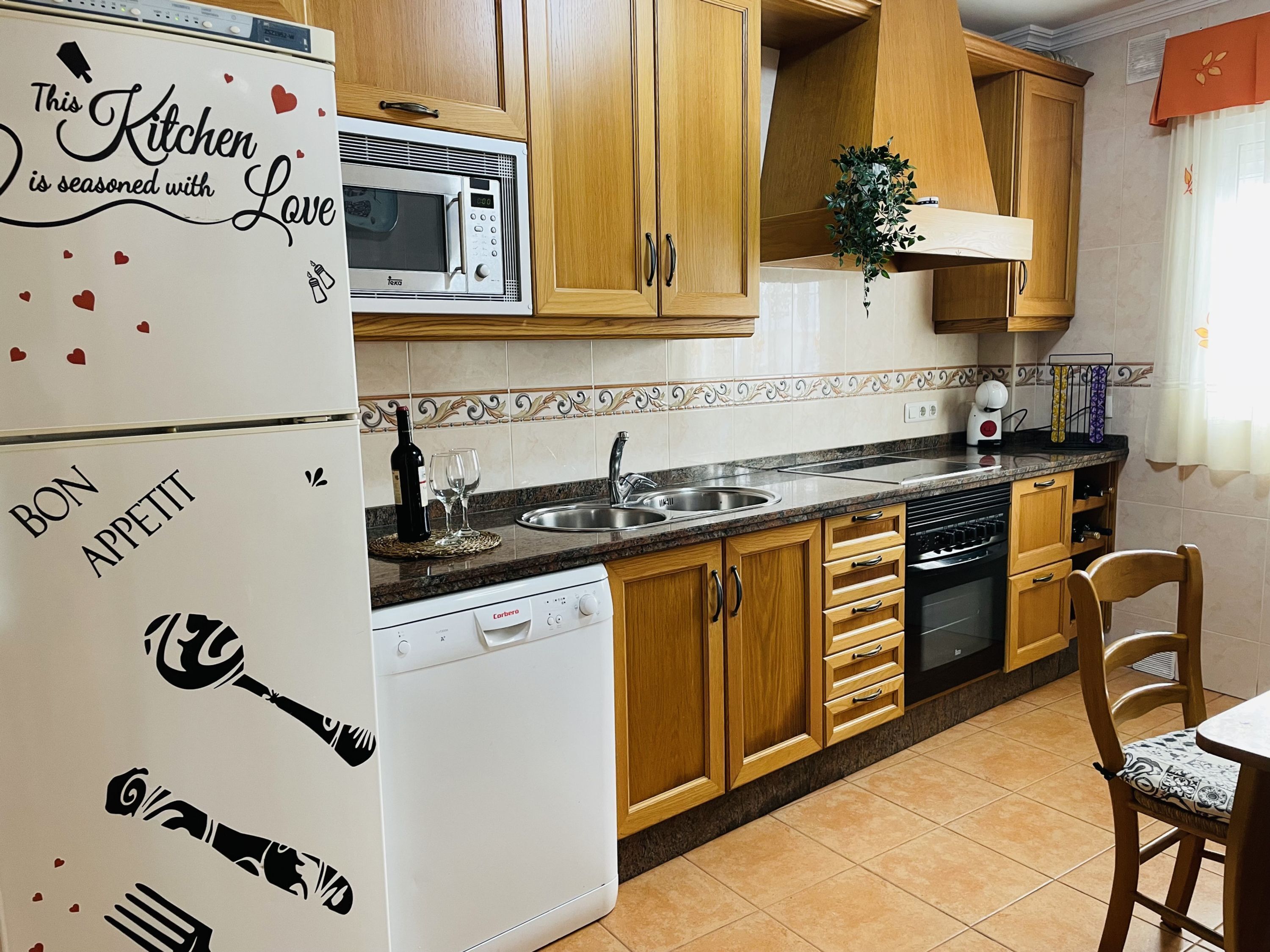 A kitchen with wooden cabinets, a microwave, a dishwasher, and a sink.