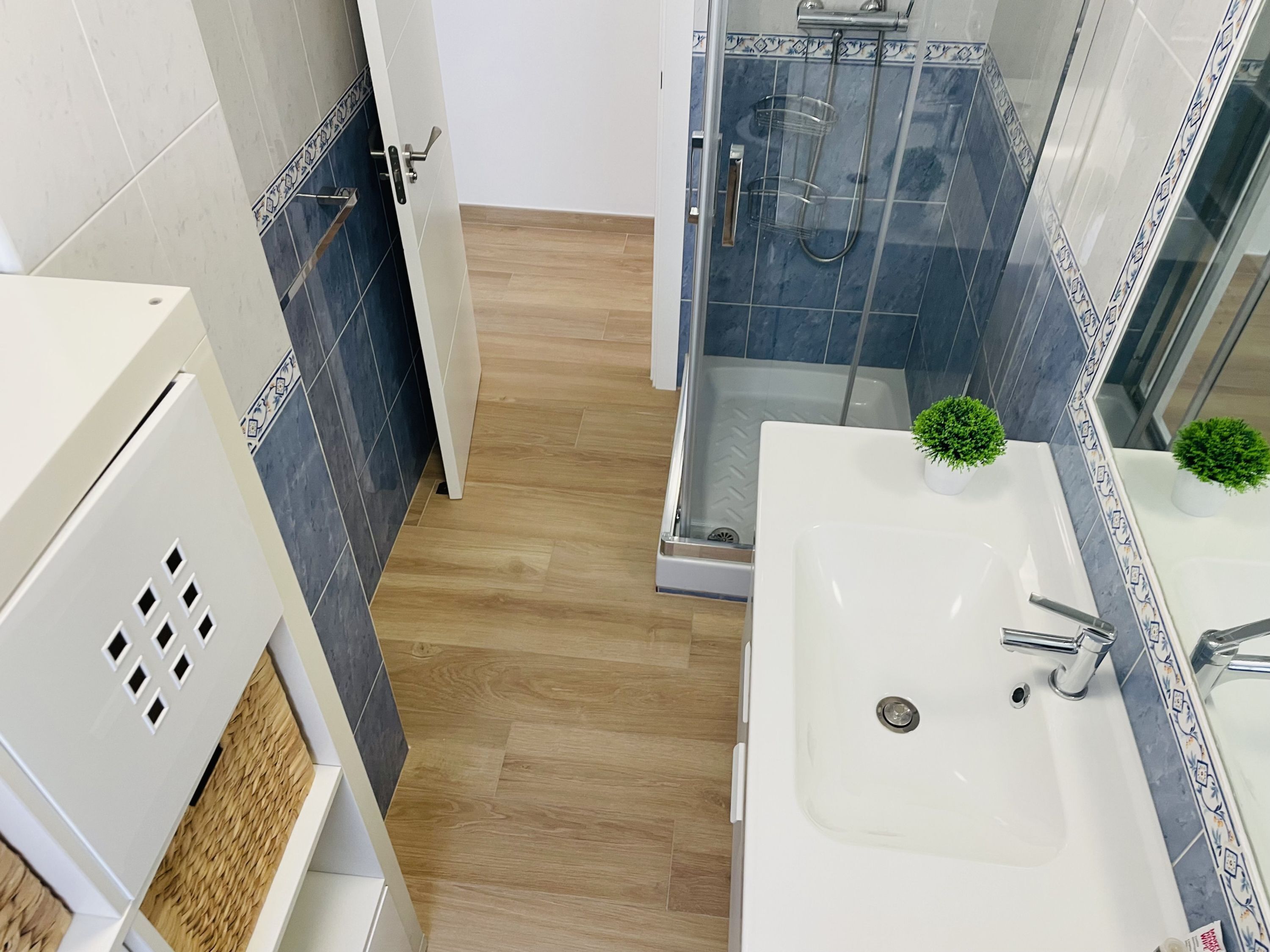 A modern bathroom with a shower, a sink, and a toilet.