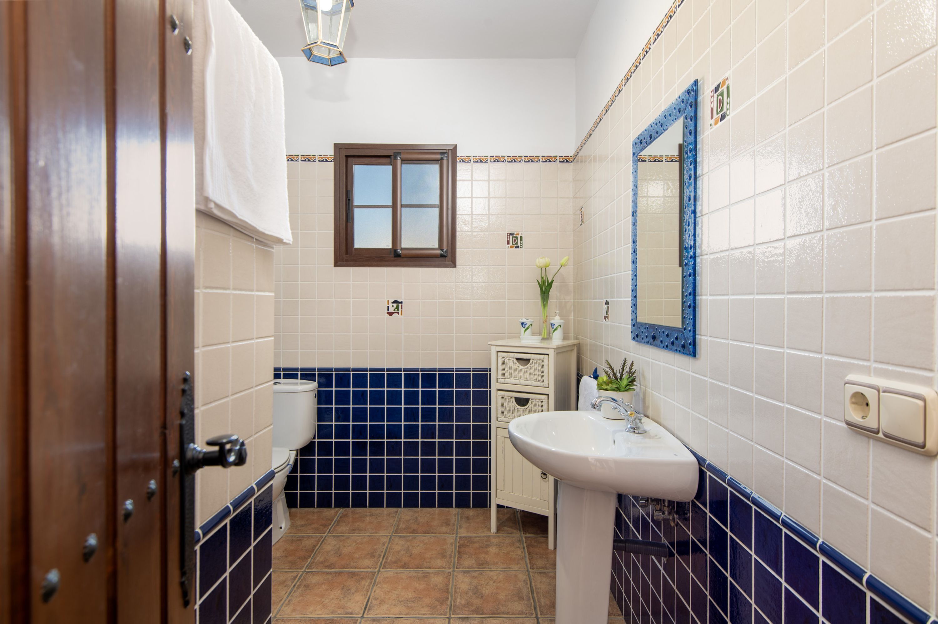 A bathroom with a toilet, sink, and a mirror.