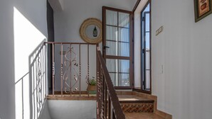 A staircase with a wrought iron railing, a round mirror, and a potted plant. - Casa Baena by At Home Costa del sol (Torrox)