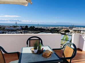 Un balcone con un tavolo apparecchiato per due, vista sulla città costiera.