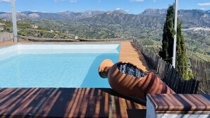 A pool with a view of mountains, a wooden deck, and a pergola structure. - Cortijo Montesue os con Vistas by At Home Costa de (Torrox)