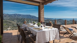 A terrace with a table set for dining, overlooking a mountainous landscape. - Casa Ascen by At Home Costa del Sol (Torrox)