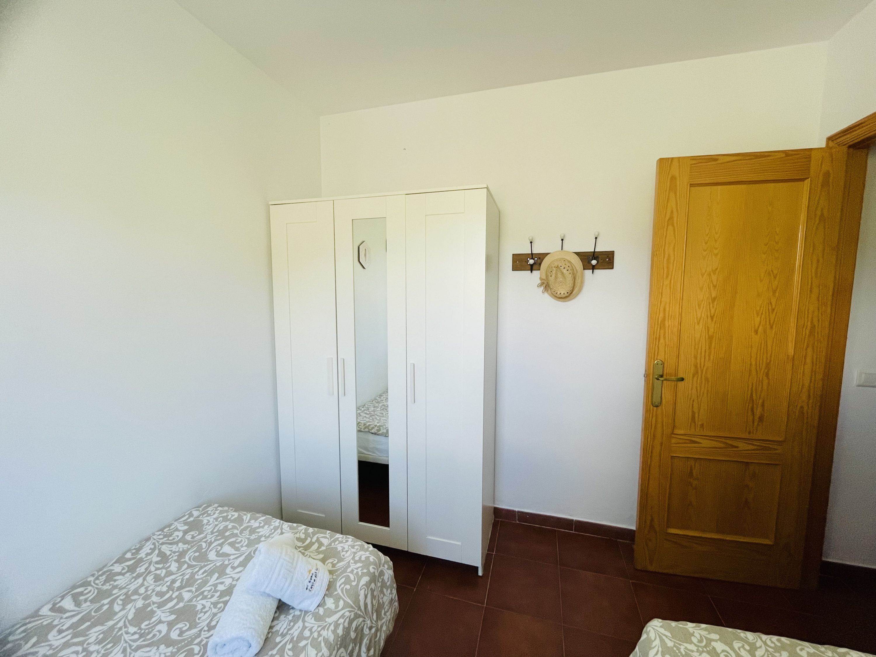 A bedroom with a bed, a wardrobe, and a wooden door.
