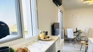 A modern kitchen with a marble countertop, a wooden cutting board, and a croissant. - Apartamento Torrox Park Sunset View (Torrox)