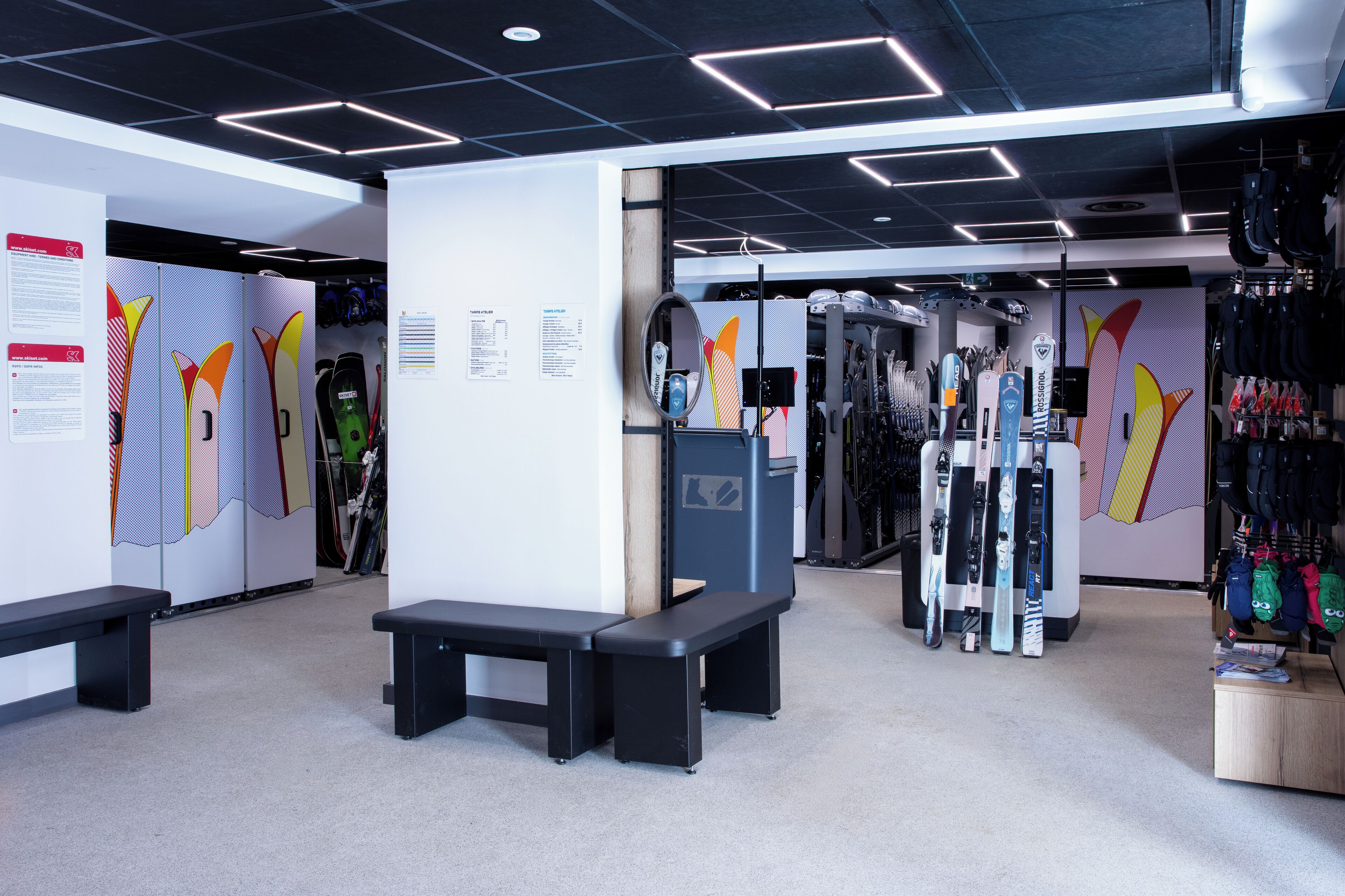 Un magasin de matériel de ski proposant des bancs, des skis et des snowboards.
