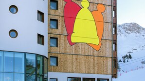 Un bâtiment orné d’une grande fresque colorée représentant une personne portant un chapeau.