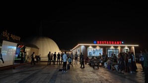 A restaurant with a dome-shaped building in the background and a crowd of people outside. - Sky View Resort (Bhuj)