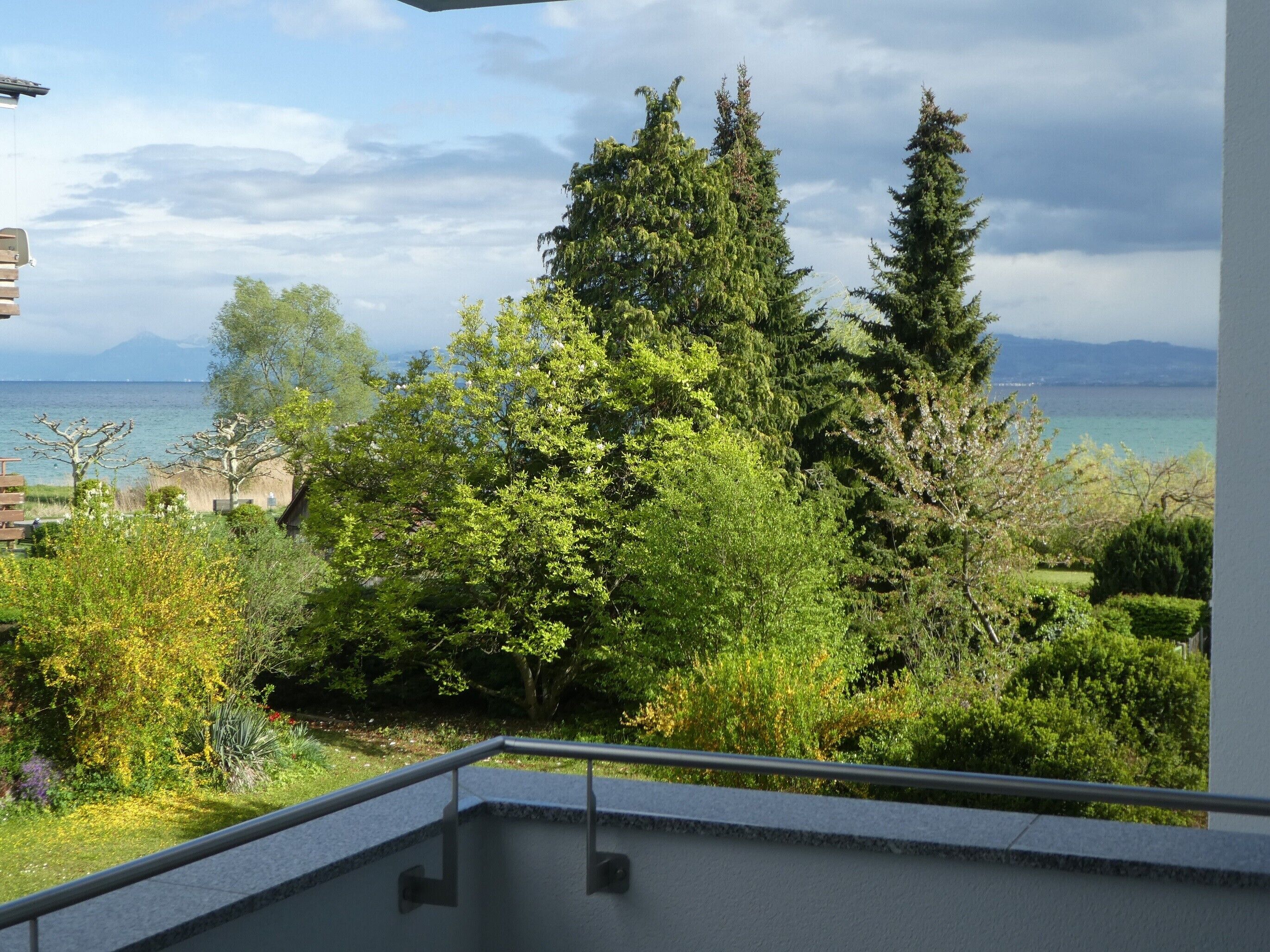 Ein Balkon mit Blick auf eine Berglandschaft und ein Gewässer.