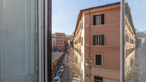 A view from a window overlooking a street with parked cars and buildings. - Rental in Rome Casa Assunta (Rome)