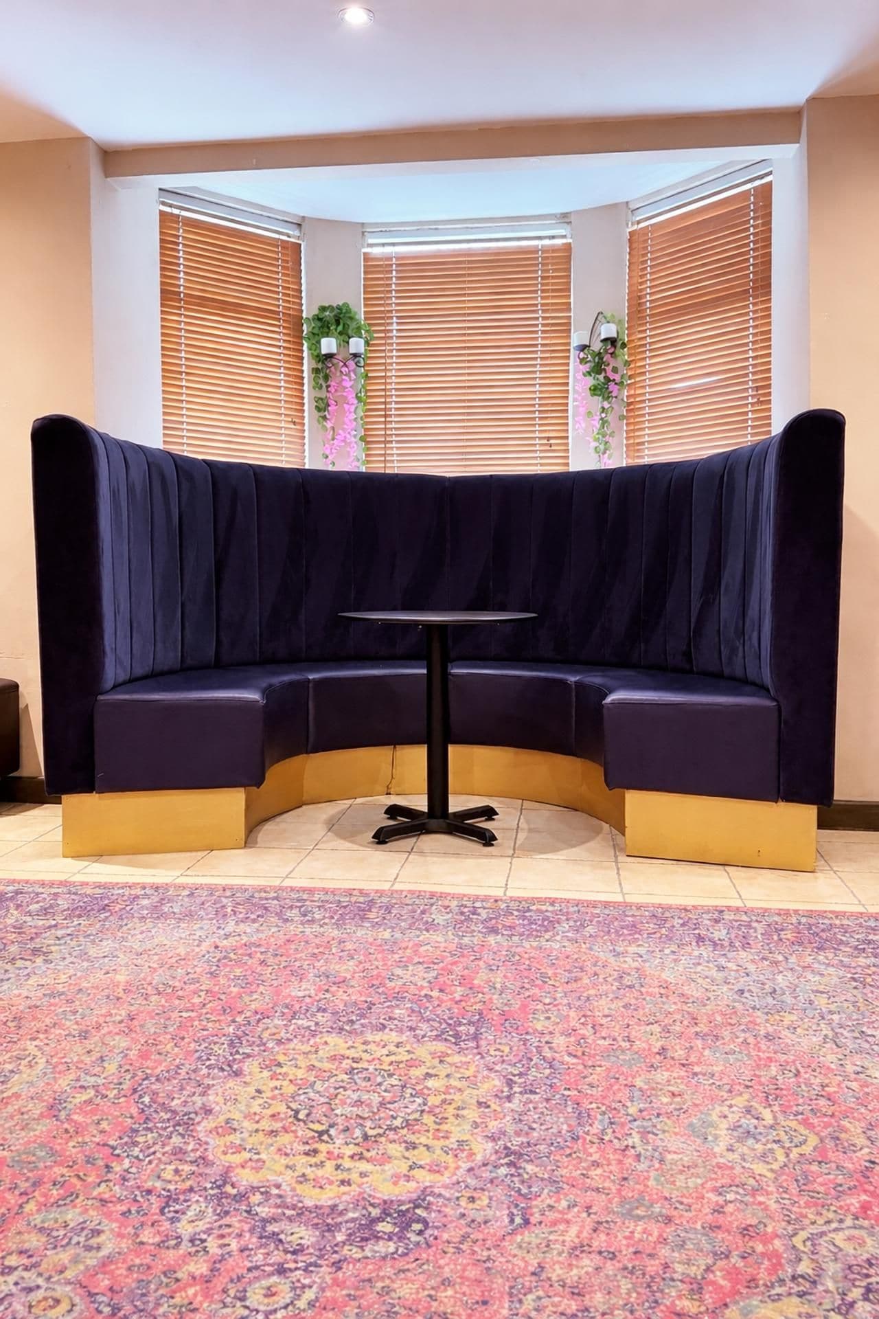 A corner seating area with a dark-colored sofa and a small round table.