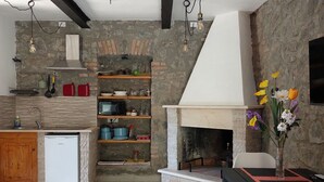 A modern kitchen with a stone wall, wooden shelves, and a built-in oven.