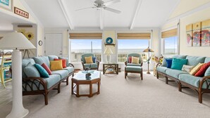 A spacious living room with two light blue sofas, a wooden coffee table, and a ceiling fan. - Oceanfront 6BR Getaway w/ Beach Access & Deck (Oak Island)