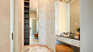 Un baño moderno con suelo de mármol, un espejo grande y una banca empotrada.