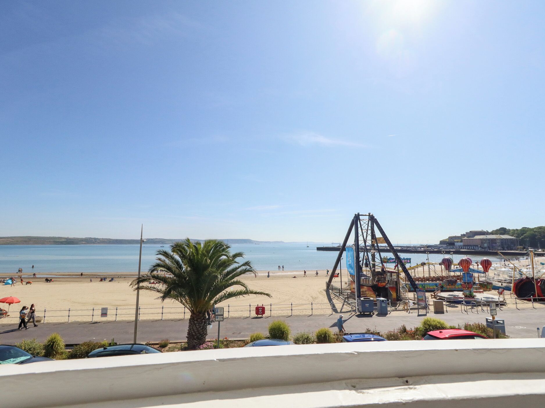 Ein Strand mit Schaukeln, Palmen und blauem Himmel.