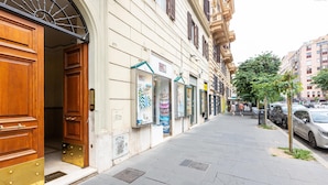 Vista de una calle con una fila de tiendas, una puerta de madera y una acera.