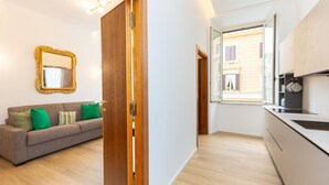 Una cocina moderna con una puerta de madera, un sofá con cojines verdes y un espejo en la pared.