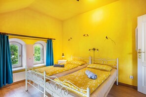 A room with two beds, a window with curtains, a bedside lamp, and a wall with bird illustrations. - Apartment '2' with Wi-Fi (Neuenkirchen)