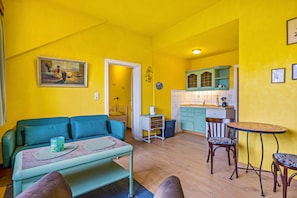 A compact living space with a sofa, a dining table, and a kitchenette.