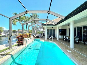 Ein überdachter Pool mit Liegestühlen und Blick auf den Yachthafen.