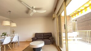 A modern living room with a sofa, a coffee table, and a dining area with chairs and a table. - Th156 Casa Vacacional con Piscina en La Mora (Tarragona)